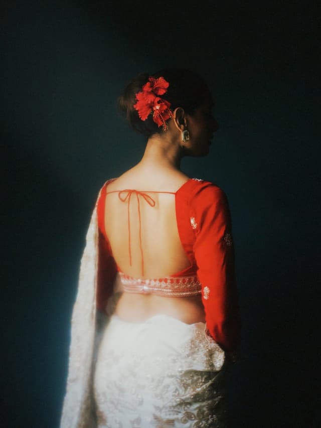 Back of a red designer saree blouse with a tie-up back