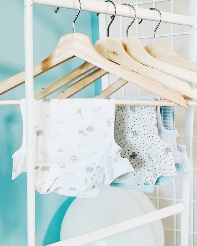 Baby onesies hanging on a clothes rack